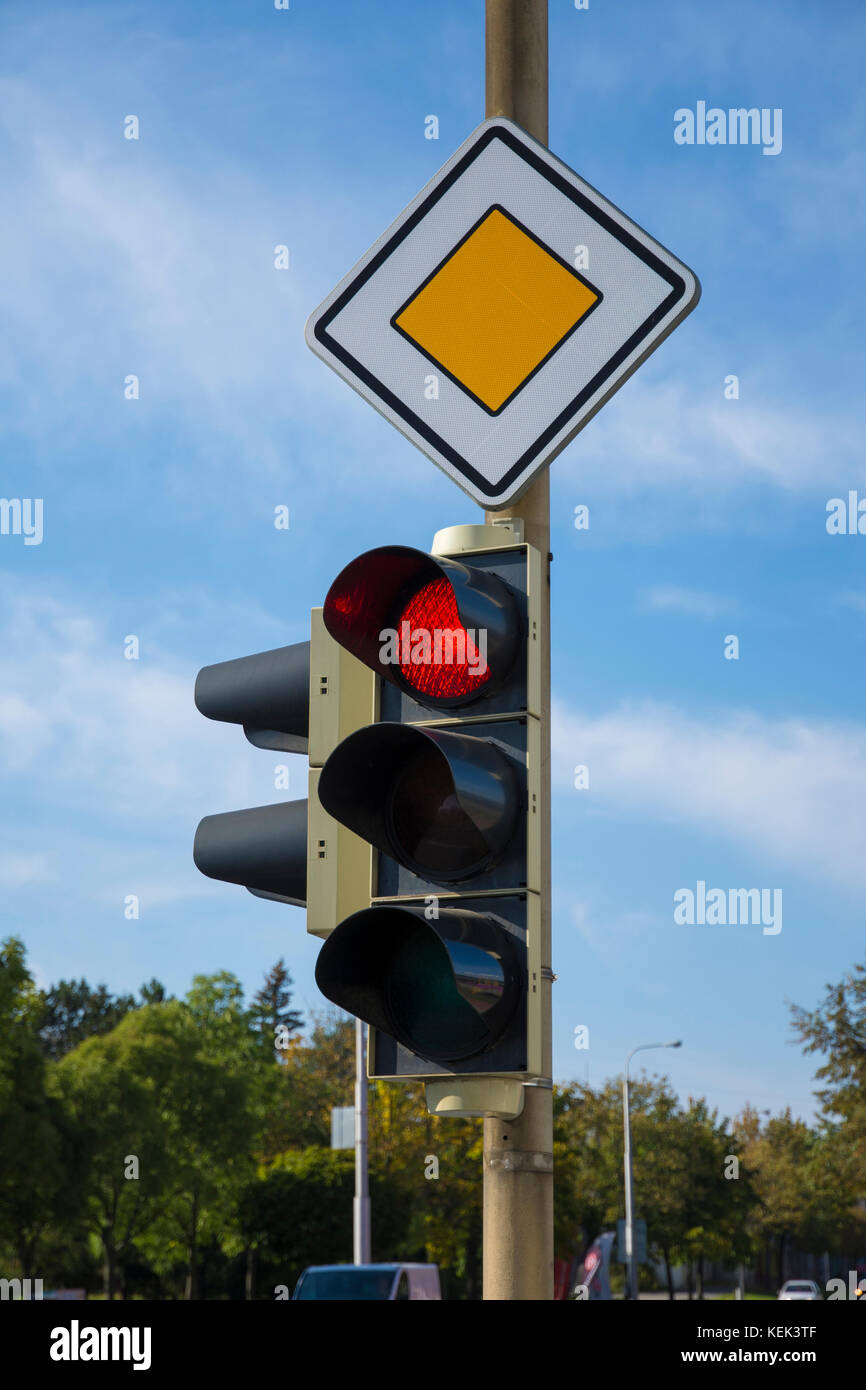 Road signs and traffic lights at a junction in the city under a blue sky Stock Photo