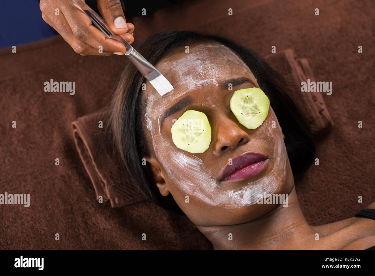 Close-up Of African Woman Applying Facial Mask In Spa Stock Photo