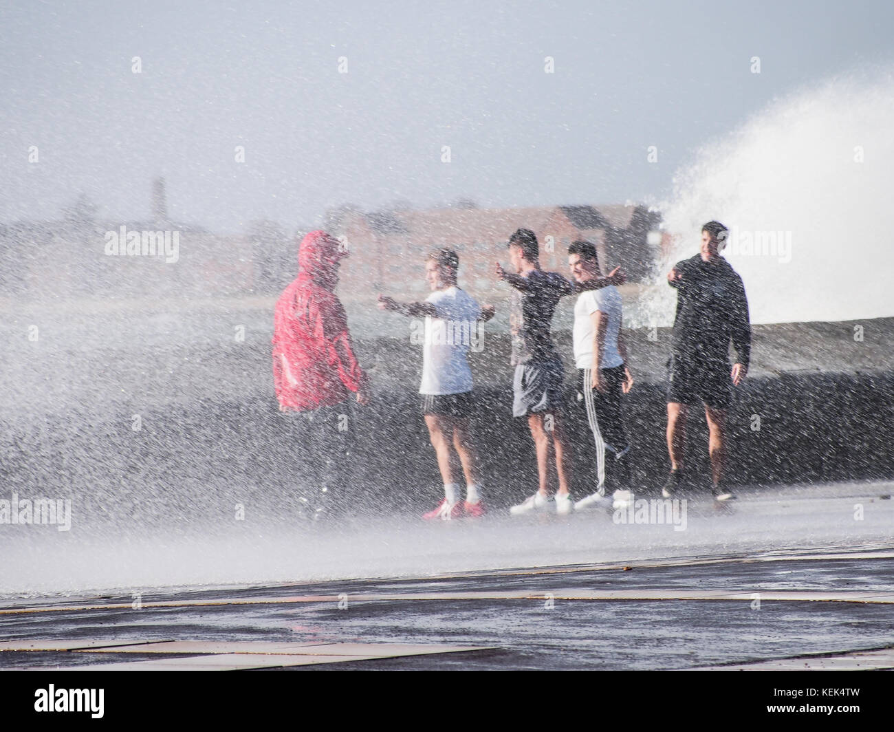 Southsea, Portsmouth, UK. 21st Oct, 2017. UK Weather. A group of teenagers make the most of the large waves breaking over the sea wall of Southsea seafront as Storm Brian hits the Southern coastline of the UK at high tide. Credit: simon evans/Alamy Live News Stock Photo