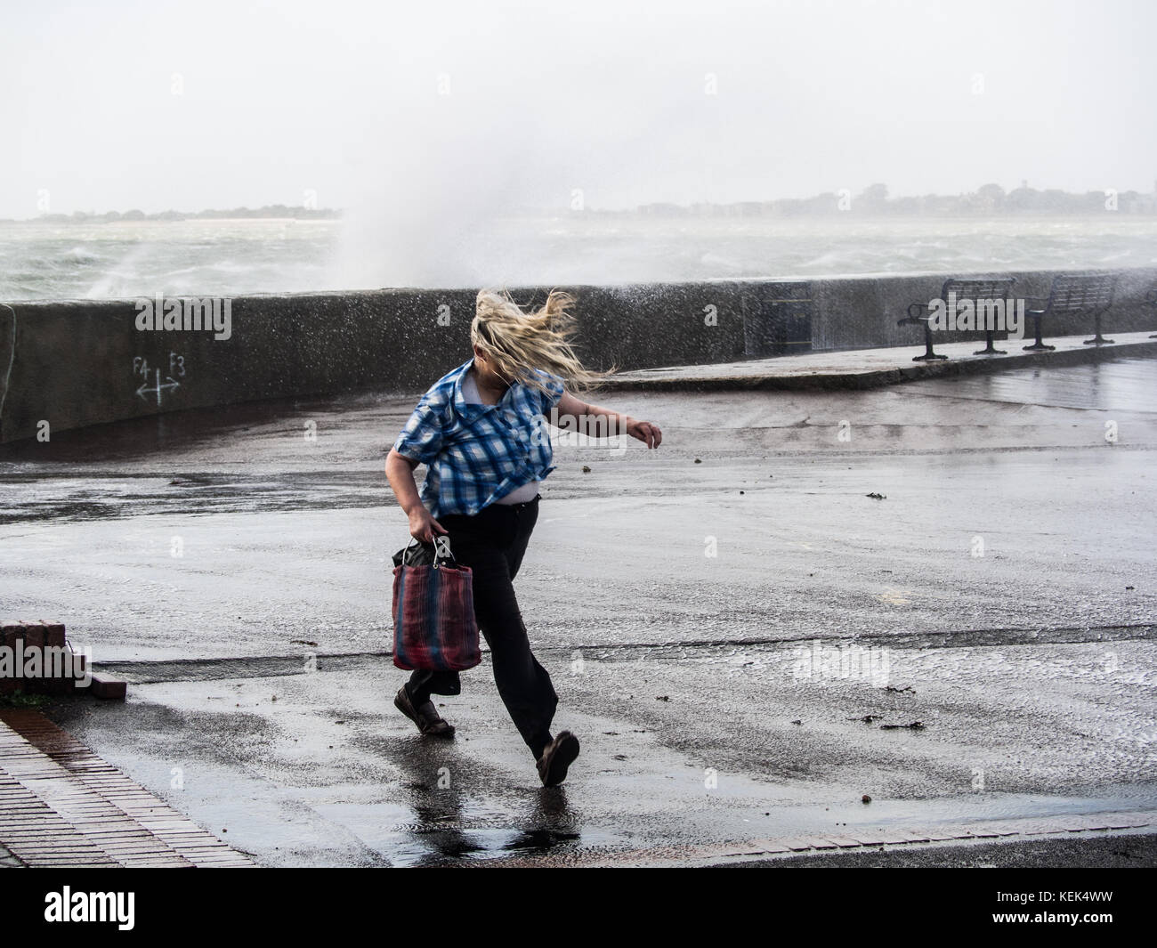 Southsea, Portsmouth, UK. 21st Oct, 2017. UK Weather. A lady struggles to walk on Southsea promenade as waves break over the sea wall of Southsea seafront as Storm Brian hits the Southern coastline of the UK at high tide. Credit: simon evans/Alamy Live News Stock Photo