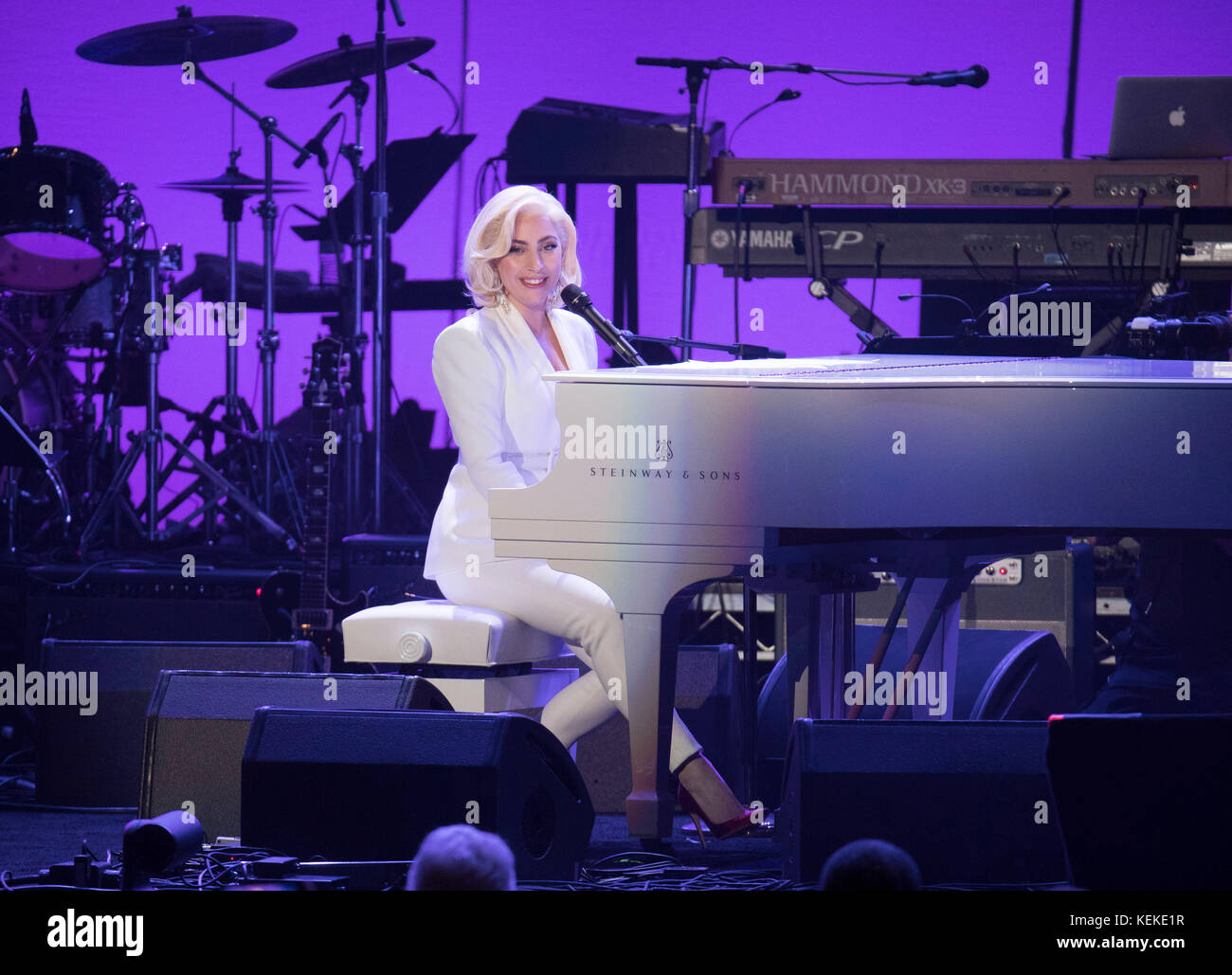 College Station, Texas USA Oct. 21, 2017: Singer Lady Gaga performs at a white grand piano on stage at the One America Appeal concert and fund raiser for hurricane and storm relief. Former U.S. presidents Jimmy Carter, George H.W. Bush, George W. Bush, Bill Clinton and Barack Obama hosted the event, held at Reed Arena on the campus of Texas A&M University. Credit: Bob Daemmrich/Alamy Live News Stock Photo