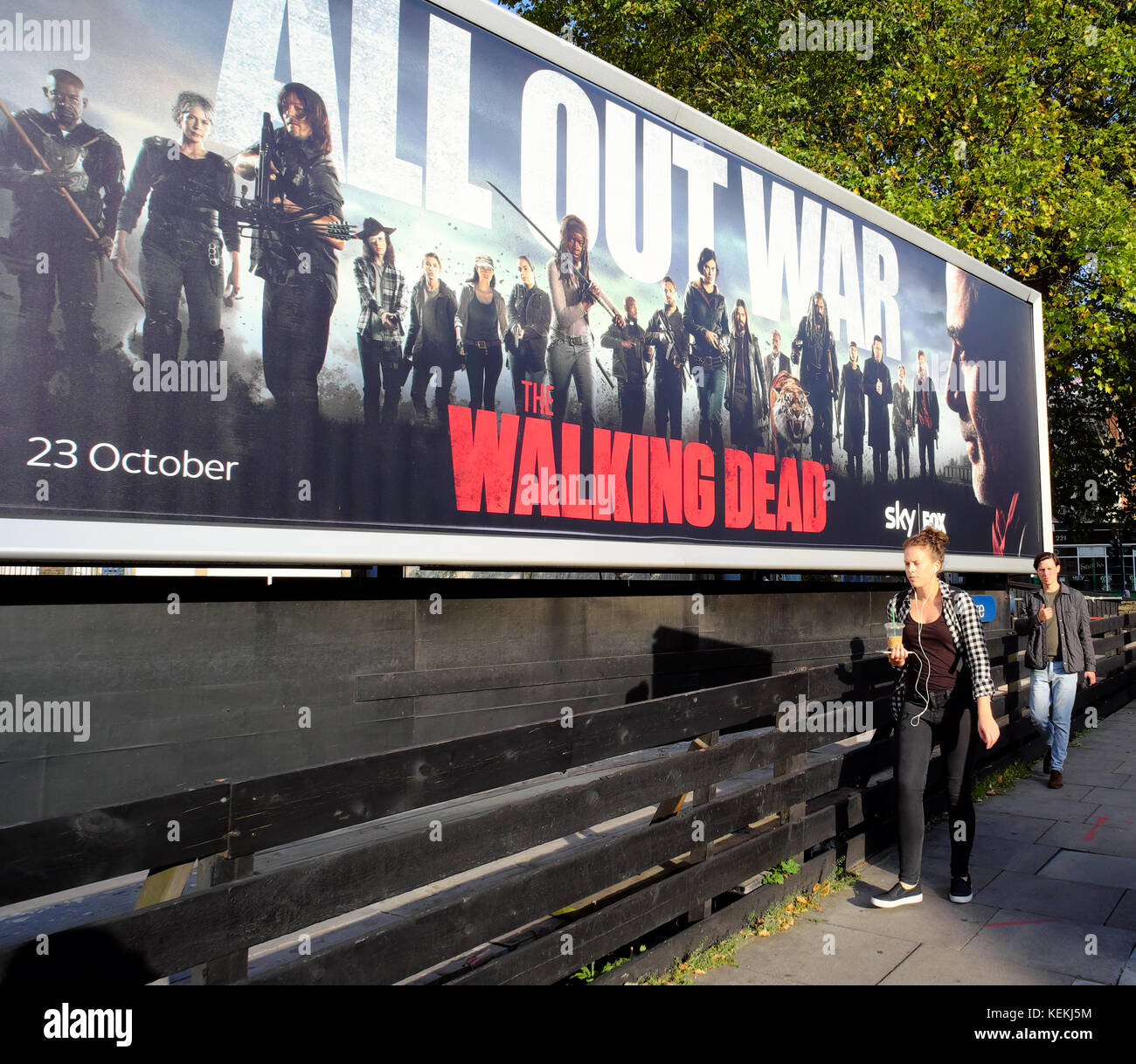 people walking past The Walking Dead billboard in London, England Stock Photo