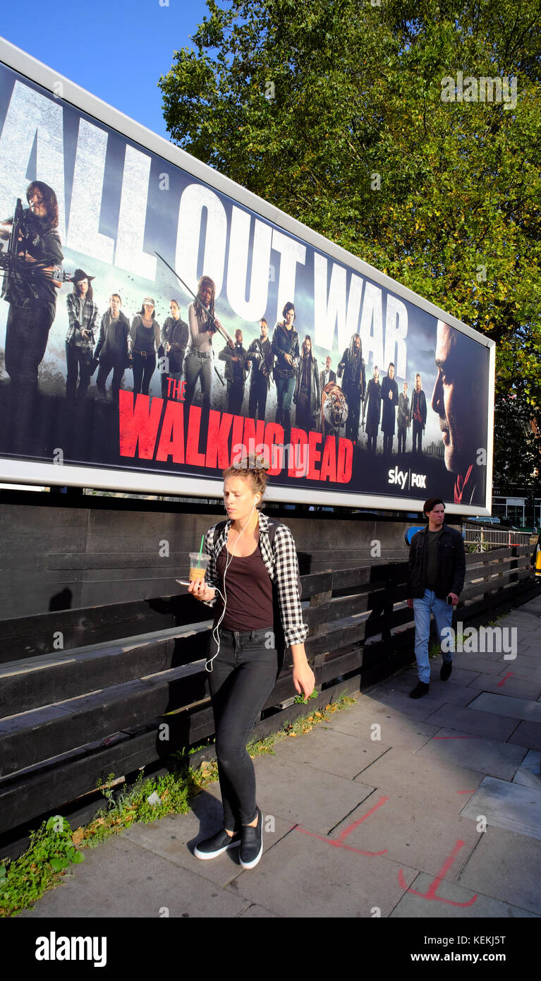 people walking past The Walking Dead billboard in London, England Stock Photo