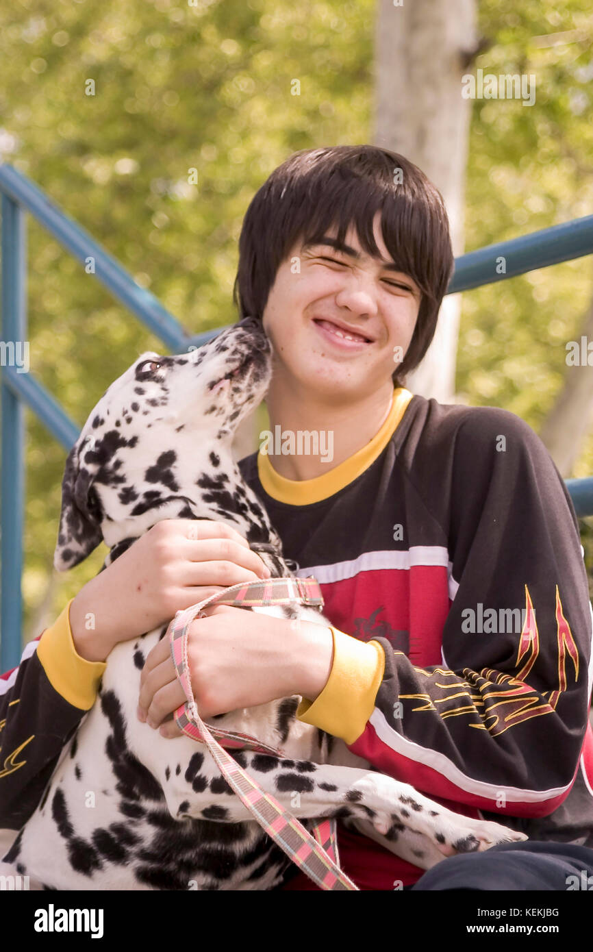 Child hugging dog Young person teen holding and playing with dog showing affection to owner dog kiss kisses licking face front view © Myrleen Pearson Stock Photo