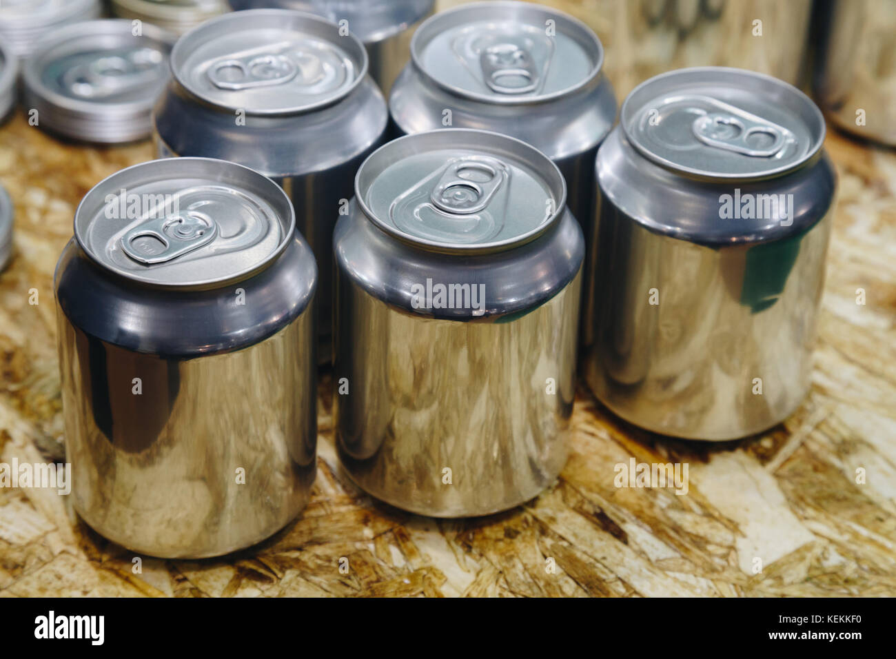 sample of aluminum cans show on the wooden table at the packaging factory. Stock Photo