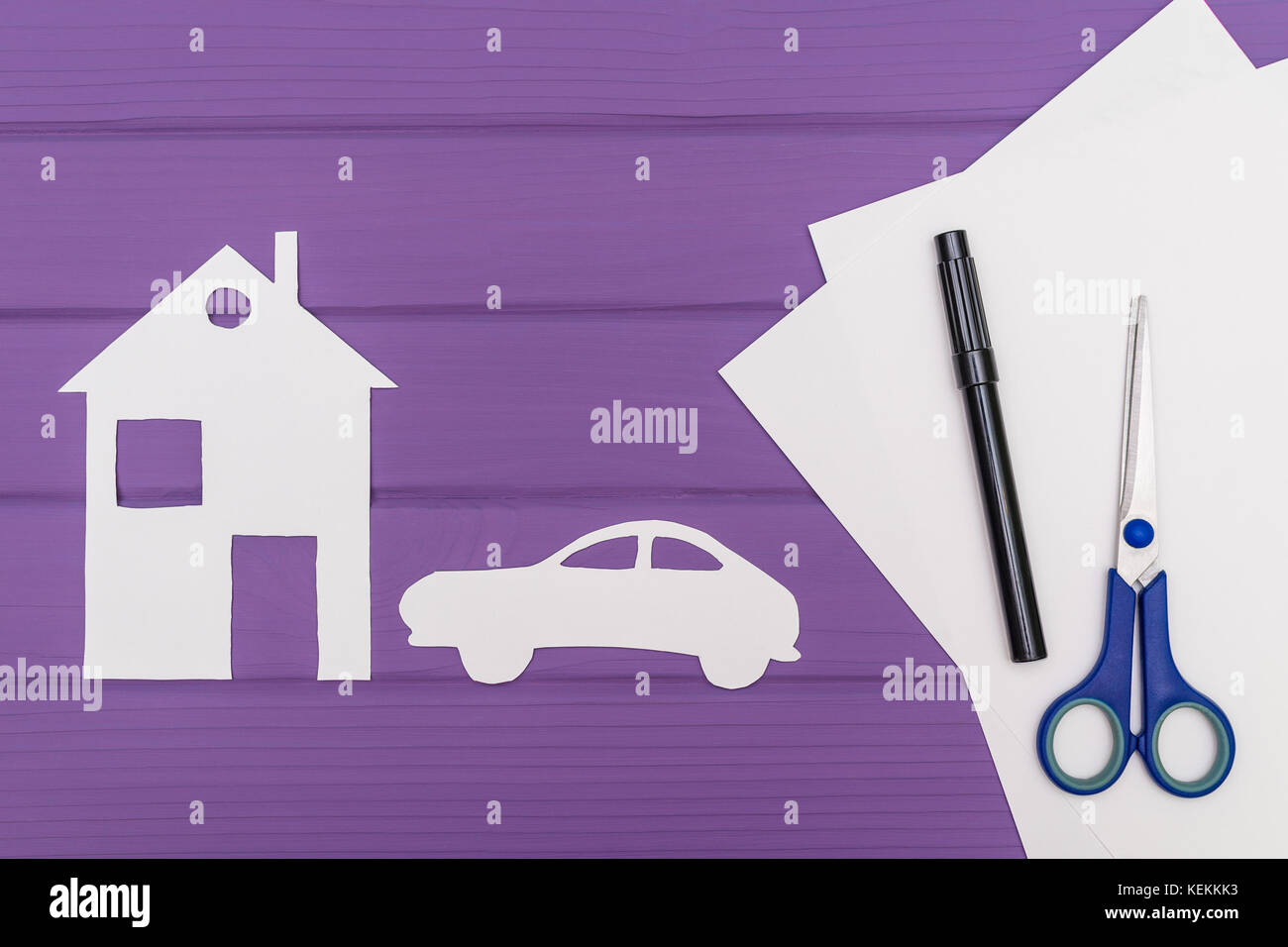 The silhouettes cut out of paper of car and house, scissors and marker ...