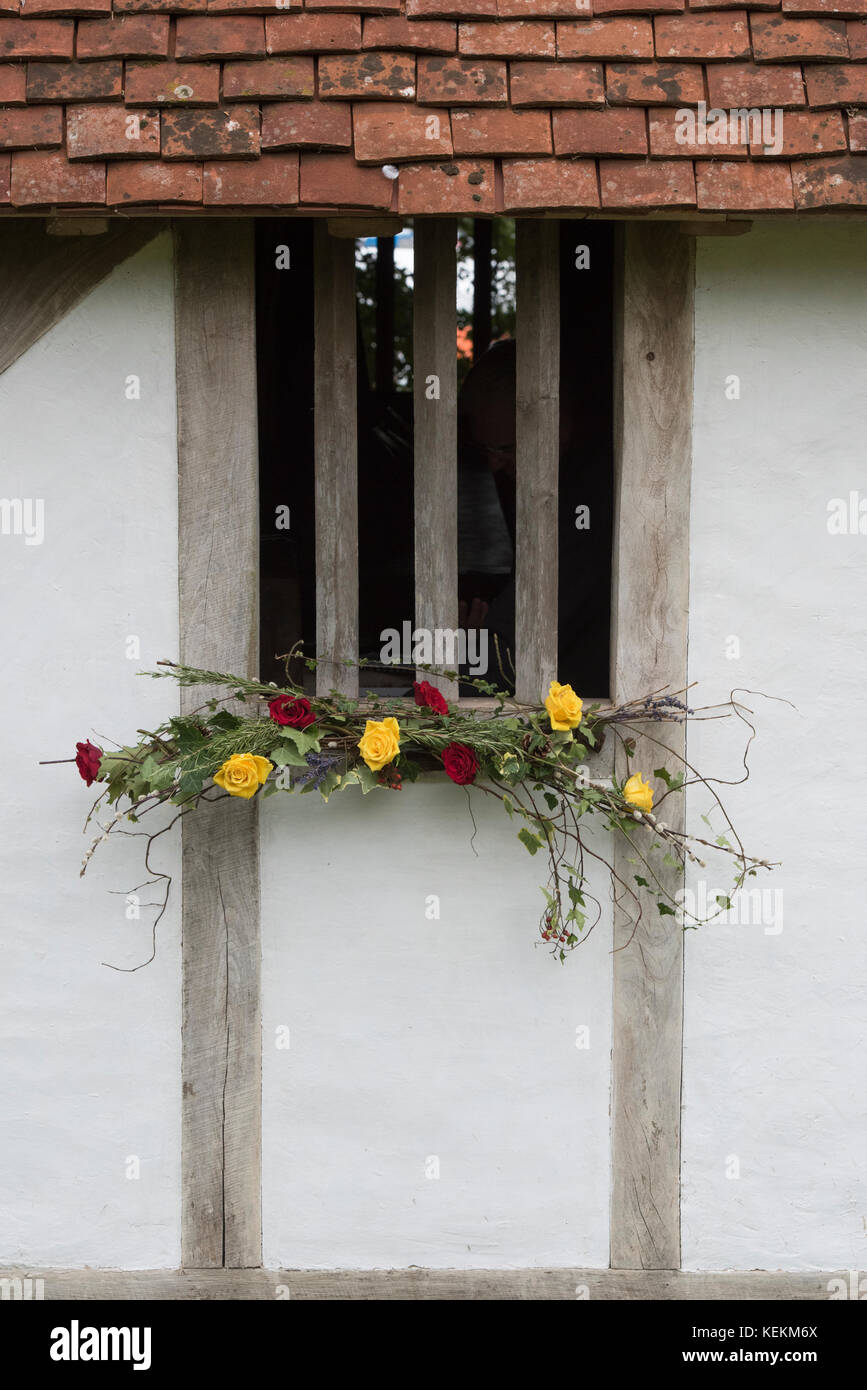 Autumn flower decoration on a medieval timber framed house window at Weald and Downland open air museum, autumn show, Singleton, Sussex, England Stock Photo