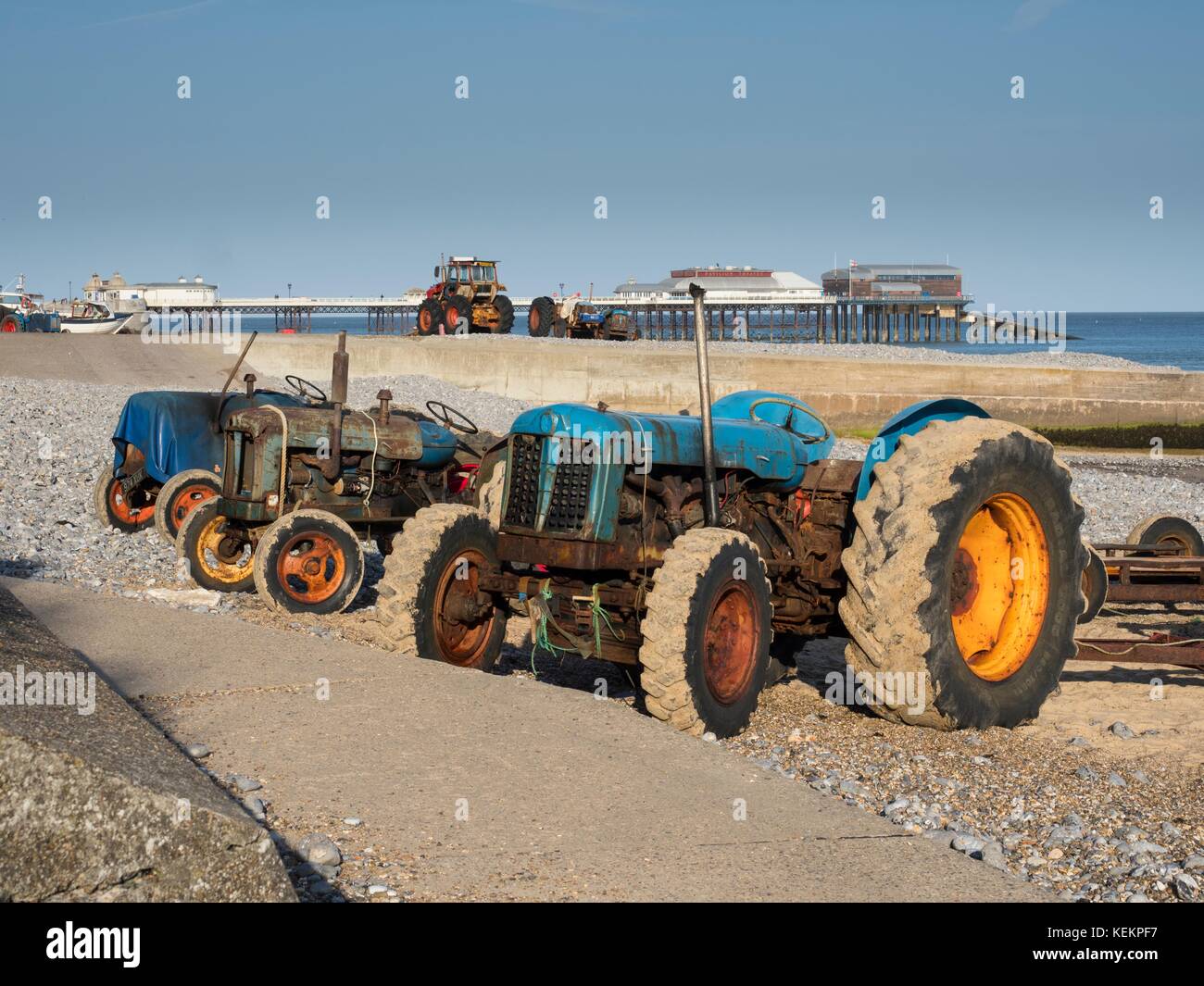 Fishermens tractors on the beach at sunny Cromer, Norfolk, England Stock Photo