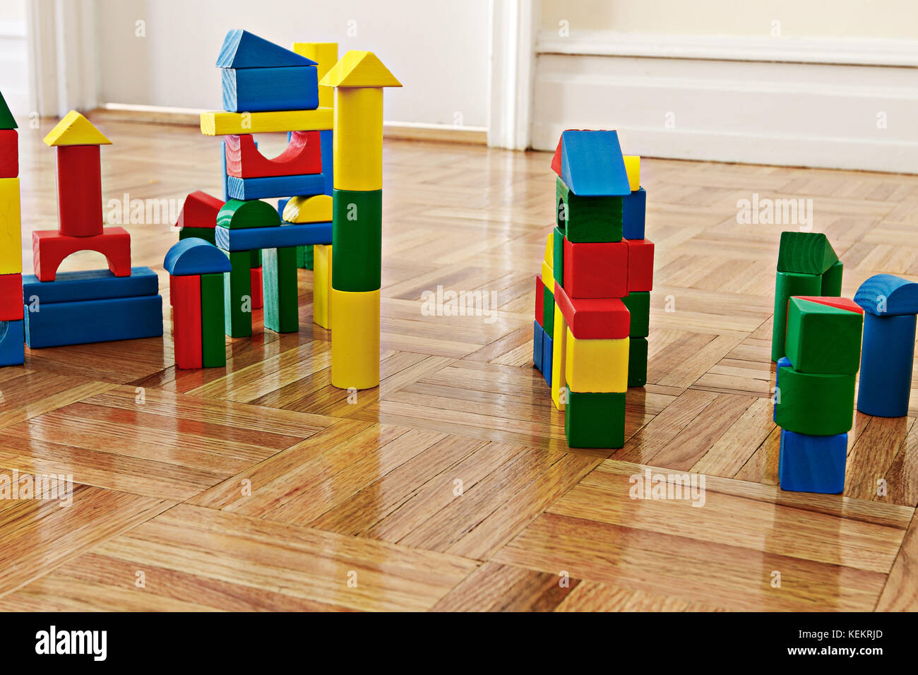 Colorful wooden building blocks on hardwood floor. Stock Photo