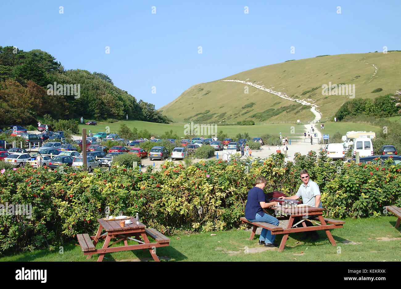 Visitors In Cafe Garden At Lulworth With Carpark And Clifftop Path