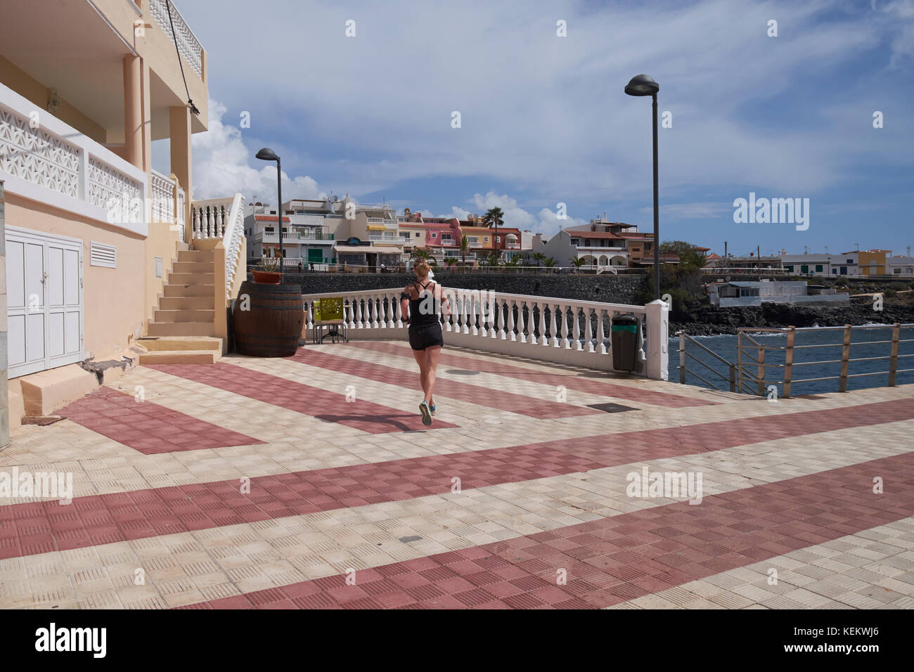 Woman jogging around seafront at La Caleta, Tenerife, Canary Islands, Spain. Stock Photo