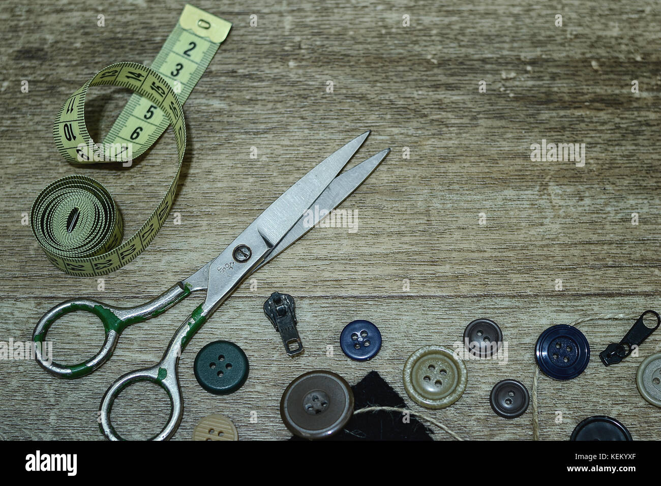Scissors and buttons on a wooden background Stock Photo - Alamy