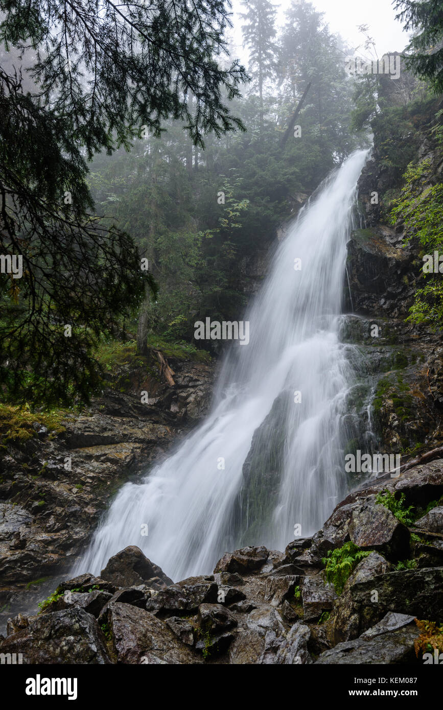 large Waterfall from ravine in autumn, long exposure, in mountain river ...