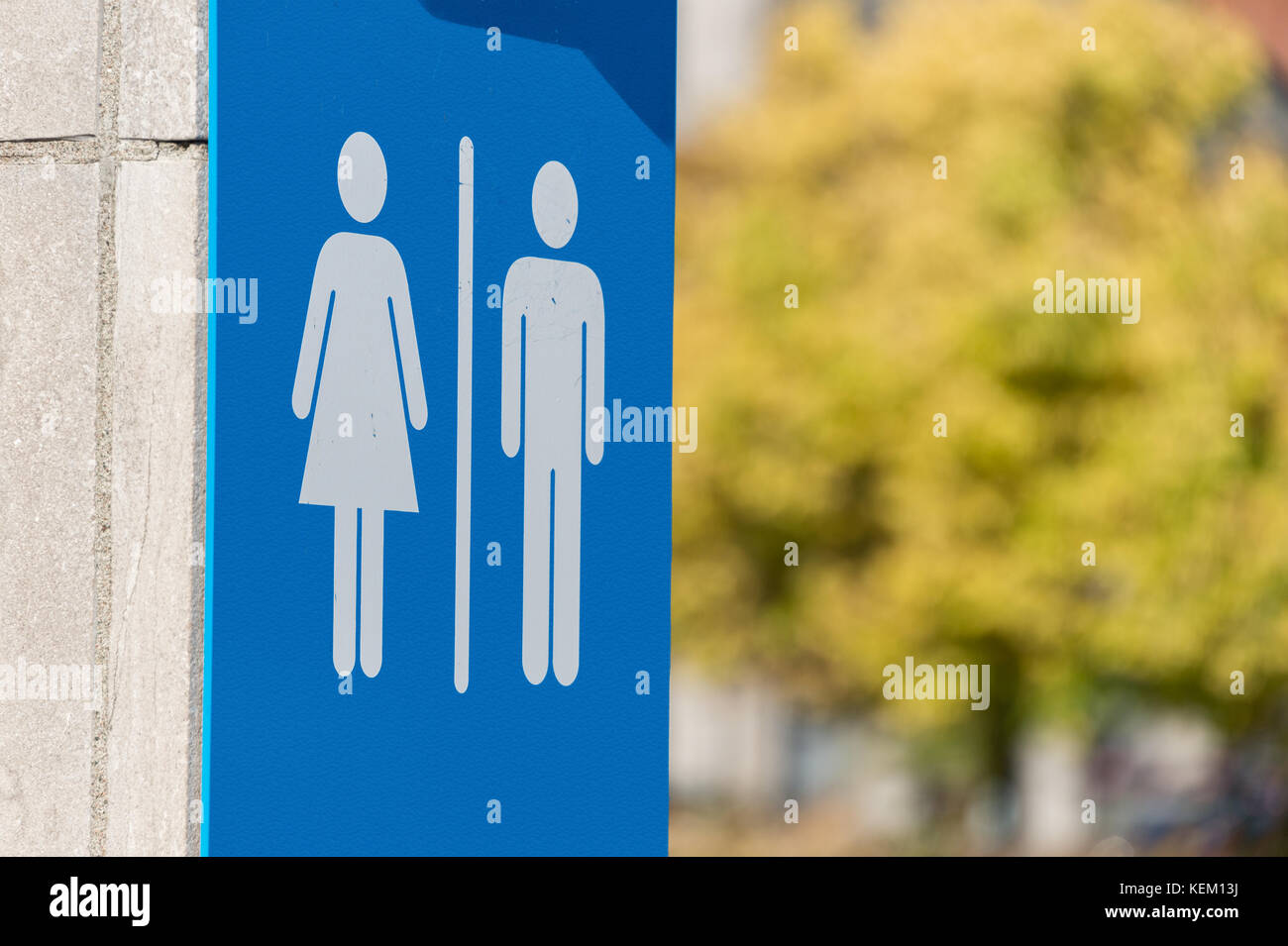 Man and woman icons, toilet sign in Montreal with autumn foliage in background Stock Photo