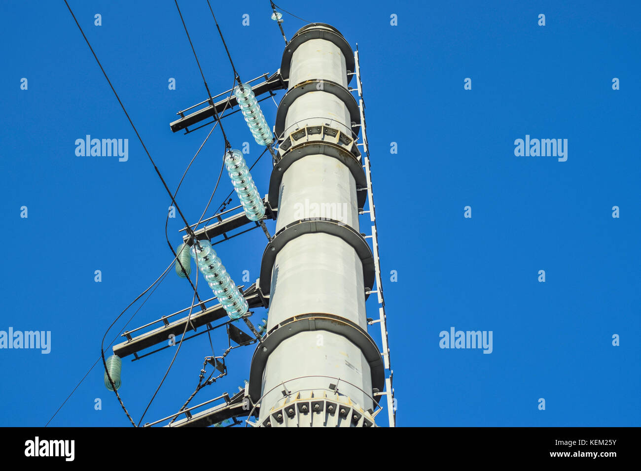 Supports high-voltage power lines against the blue sky Stock Photo - Alamy