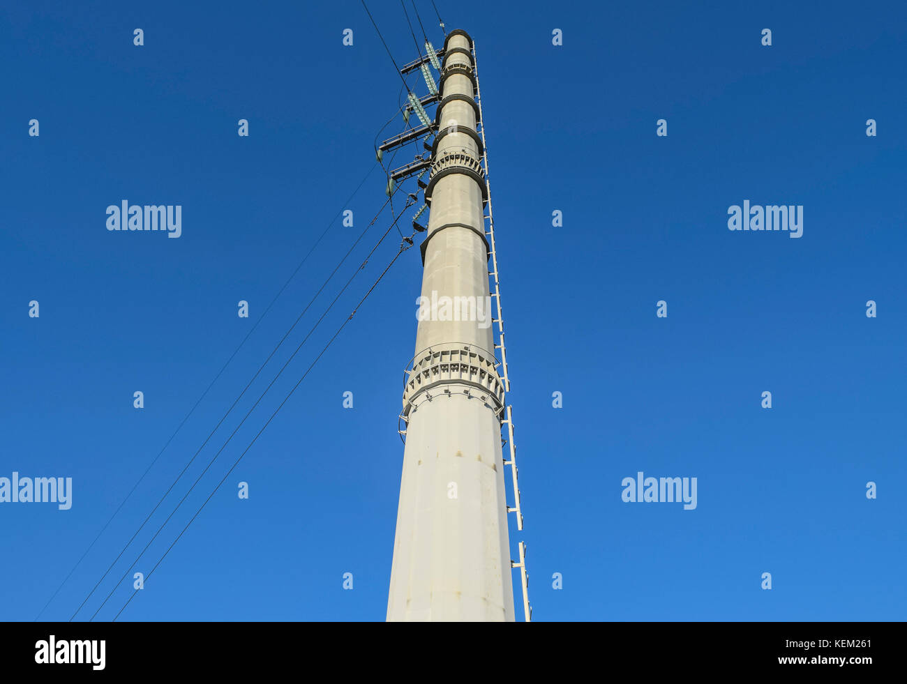 Supports high-voltage power lines against the blue sky Stock Photo - Alamy