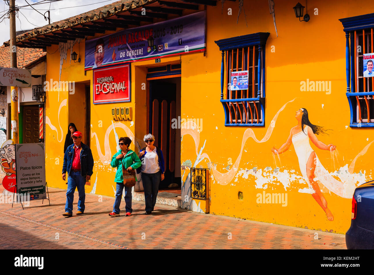 Colombia, South America - People Leaving The Restaurante El Colonial In The Town Of Nemocón, In The Cundinamarca Department. Afternoon Sunlight. Stock Photo
