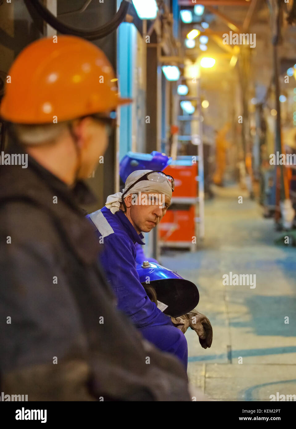 Workers fitters and welders in protective clothing and a helmet ...