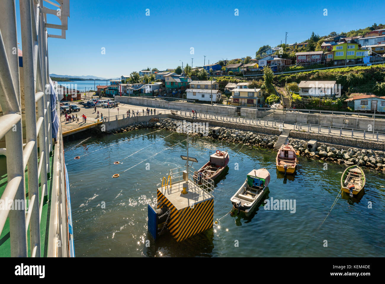 Boats at wharf and houses in Puerto Aguirre, view from a ferry, at Isla