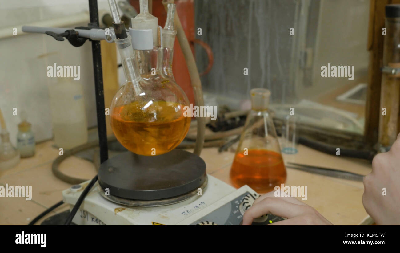 Scientist mixing liquids in flasks in a research lab. Special equipment