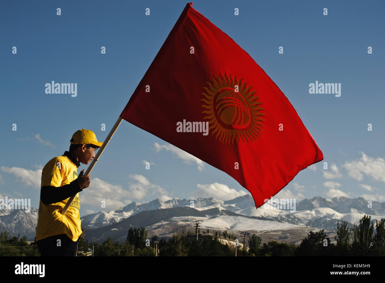 Teenage boy holding a kyrgyz flag during a political meeting ( Kyrgyzstan) Stock Photo