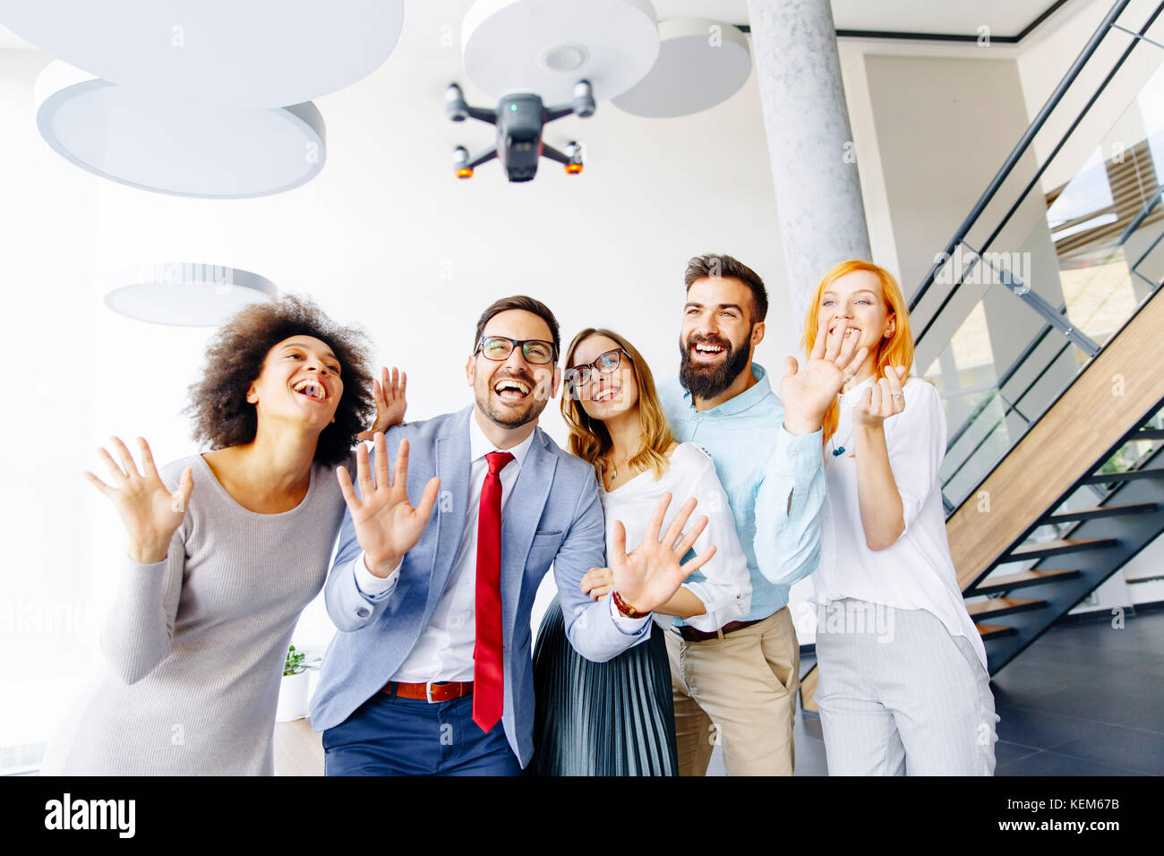 Young business people letting the drone camera to fly over the office ...