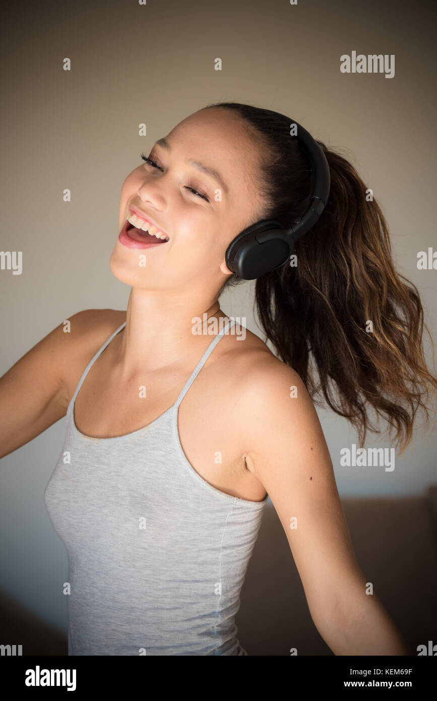 Young asian teen woman portrait closed eyes smiling and dancing with headphones female lifestyle Stock Photo