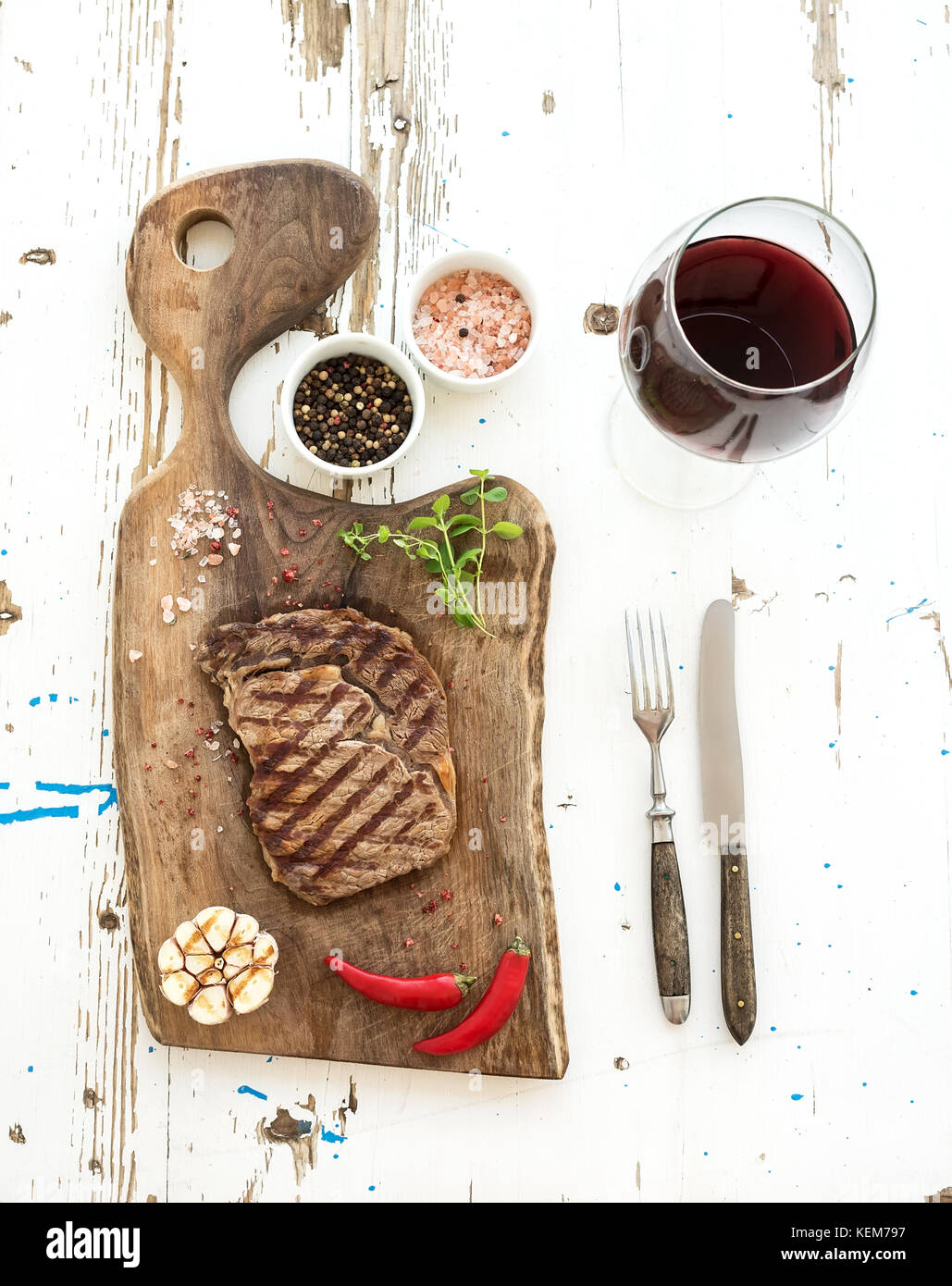 Grilled ribeye beef steak with herbs, spices and glass of red wine on ...