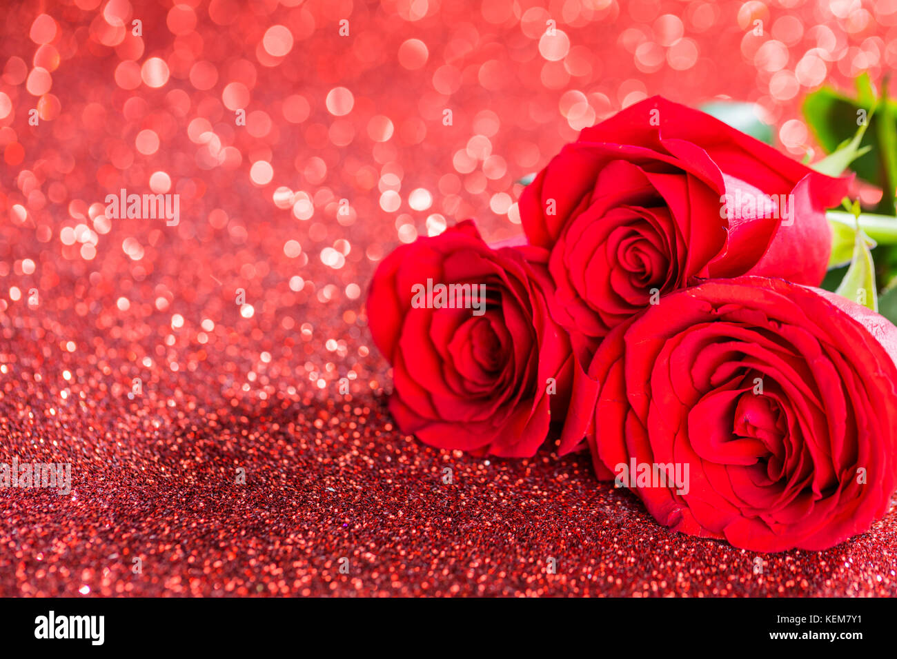 Three beautiful red roses on glitter background Stock Photo - Alamy