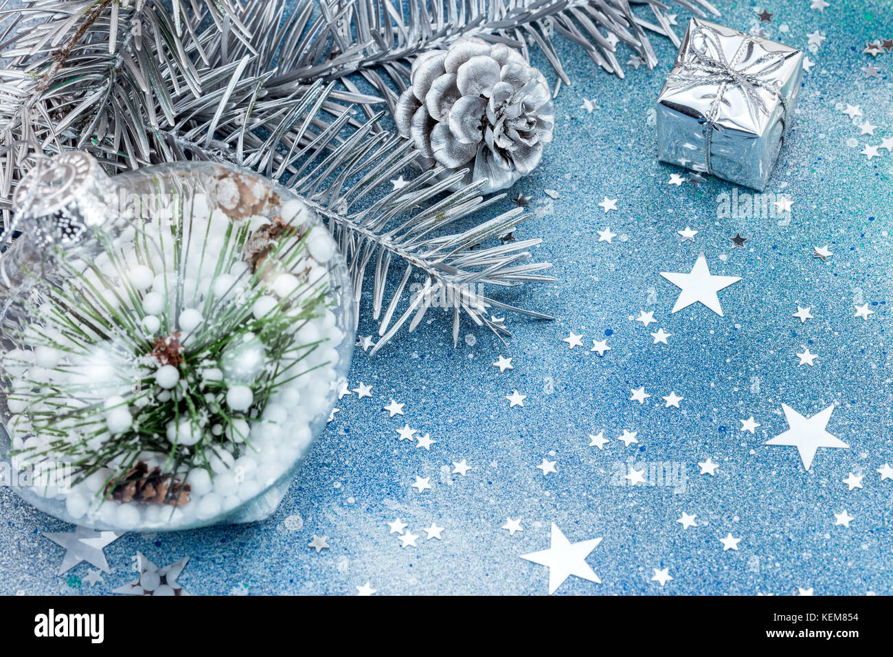 christmas fir tree branch decorations on blue glitter background with ...