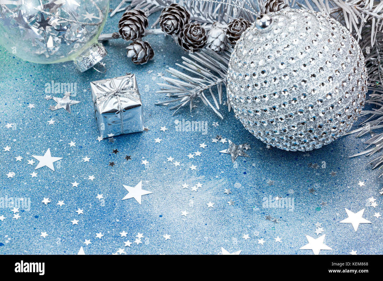 christmas tree branch with silver cones and christmas decorations on ...