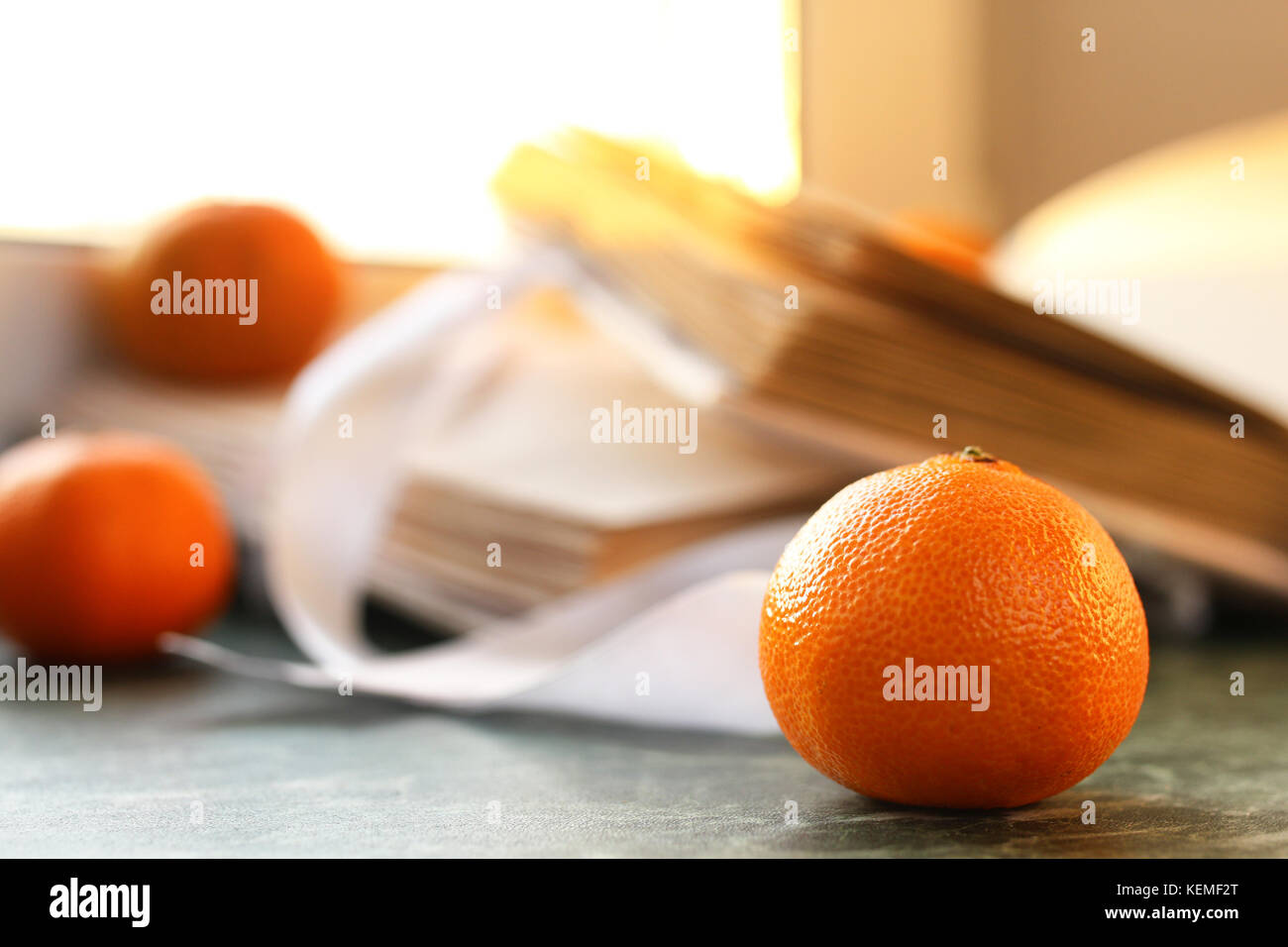 tangerines and vintage books on a marble table by the window Stock