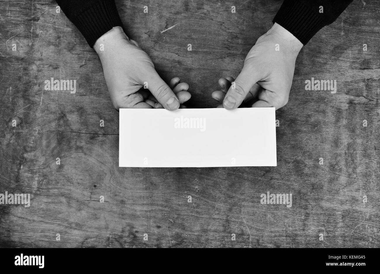 monochrome photo male hands holding a white blank sheet of paper Stock ...
