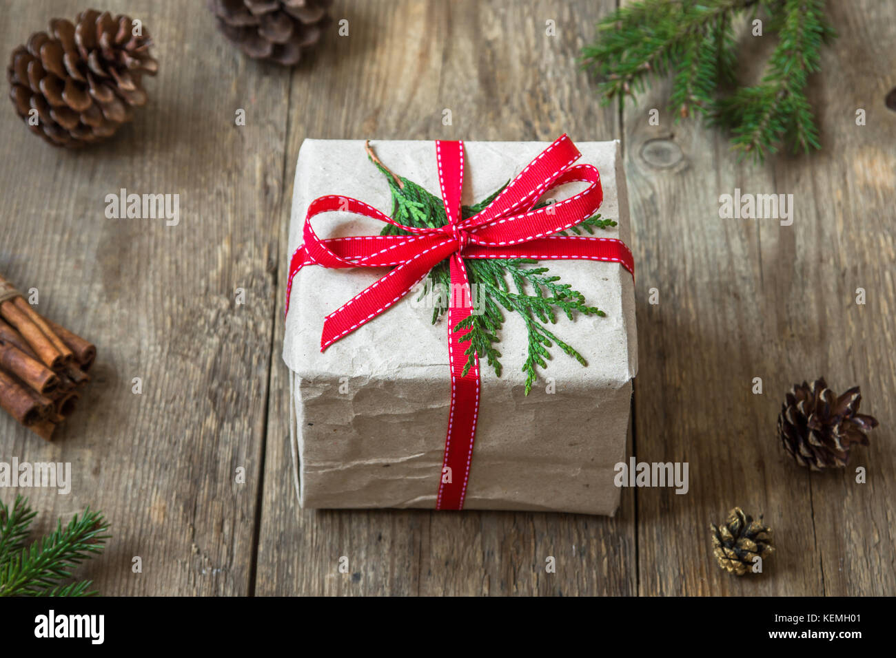 Christmas gift box with fir branches and cones on wooden background ...