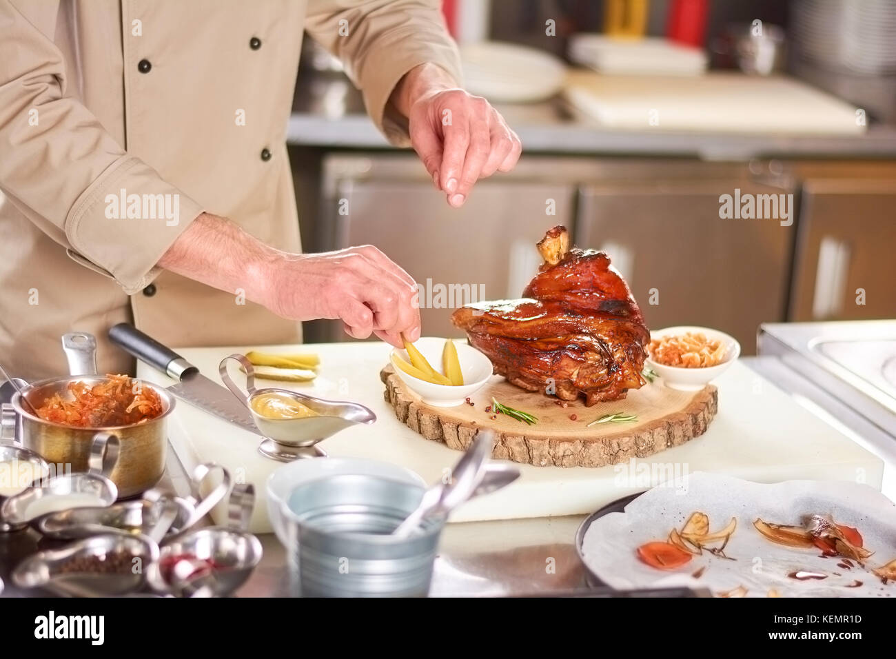 Lamb shank on natural wood. Male chef serving with vegetables roasted lamb shank. Delicious food of european restaurant. Stock Photo