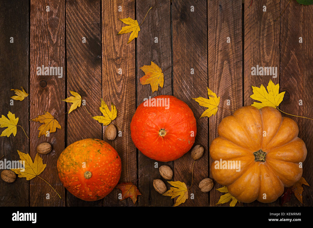Thanksgiving background: Pumpkins and fallen leaves on white wooden ...