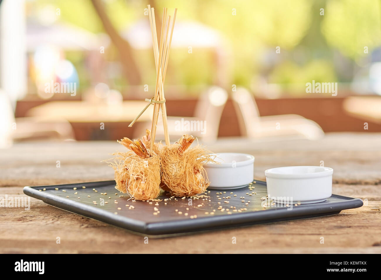 Crispy shrimps on blurred background. Shrimps wrapped in kataifi dough. Delicious food on plate. Stock Photo