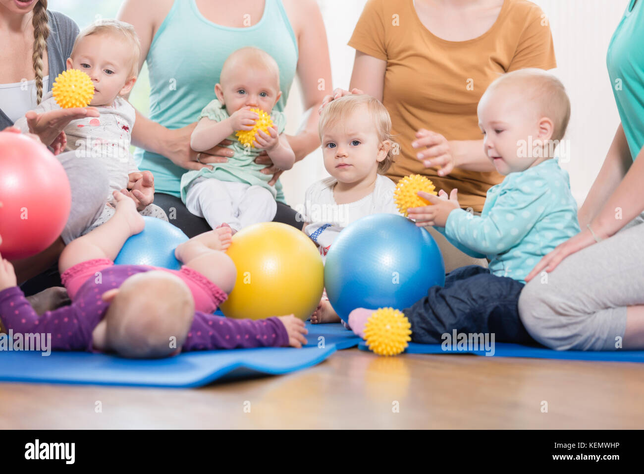 Young women in mother and child group playing with their baby ki Stock