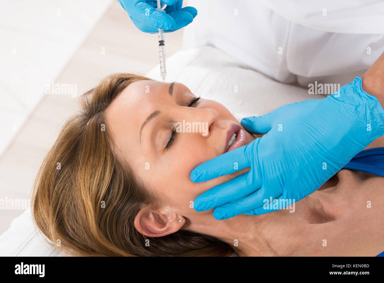 Mature Woman Receiving Cosmetic Injection With Syringe In Beauty Clinic Stock Photo