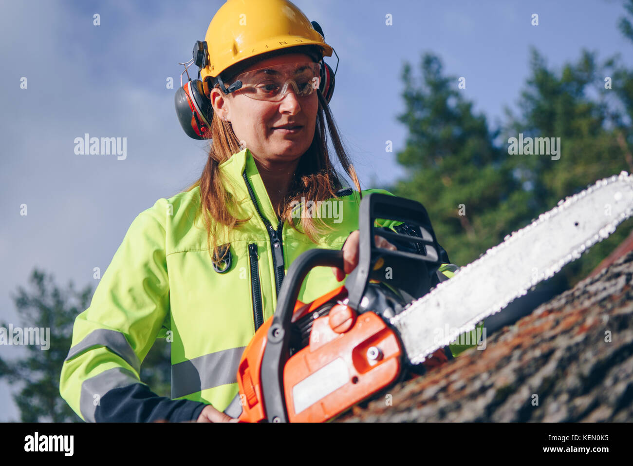 Woman operating chainsaw while wearing safety gear Stock Photo Alamy
