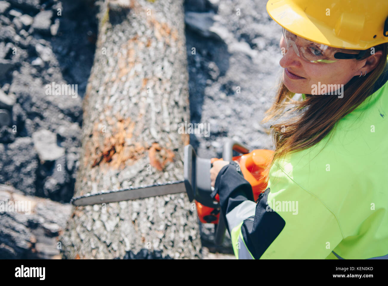 Woman operating chainsaw while wearing safety gear Stock Photo Alamy