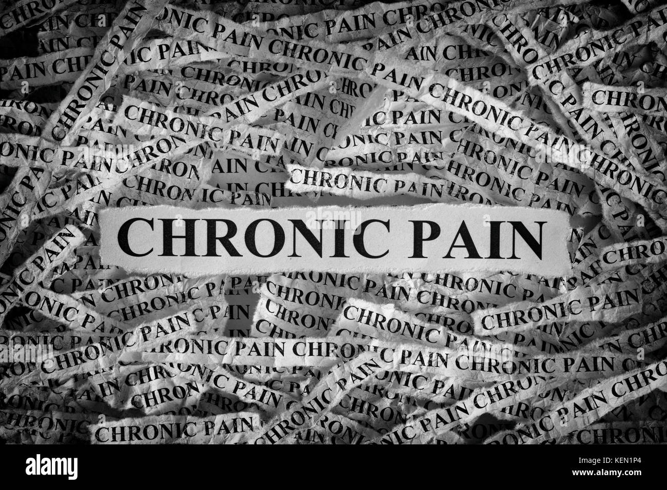 Chronic Pain. Torn pieces of paper with the words Chronic Pain. Concept Image. Black and White. Closeup. Stock Photo