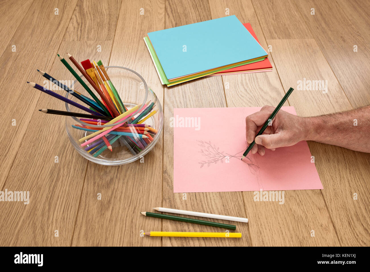 Illustrator is drawing a sketch he works with colored pencils and colored paper Stock Photo
