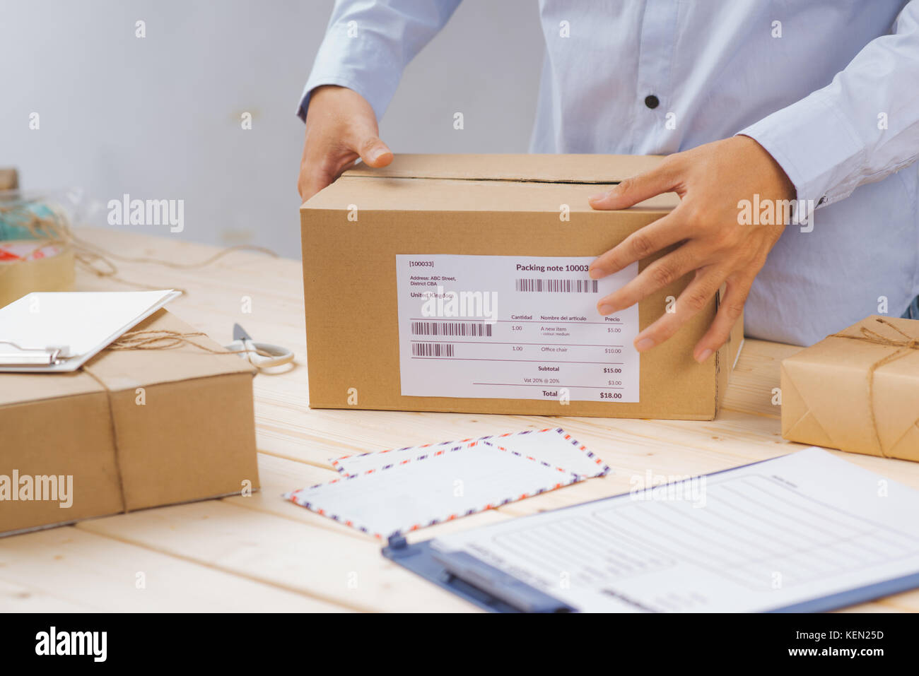 Deliveryman taping and packing cardboard box for delivery Stock Photo