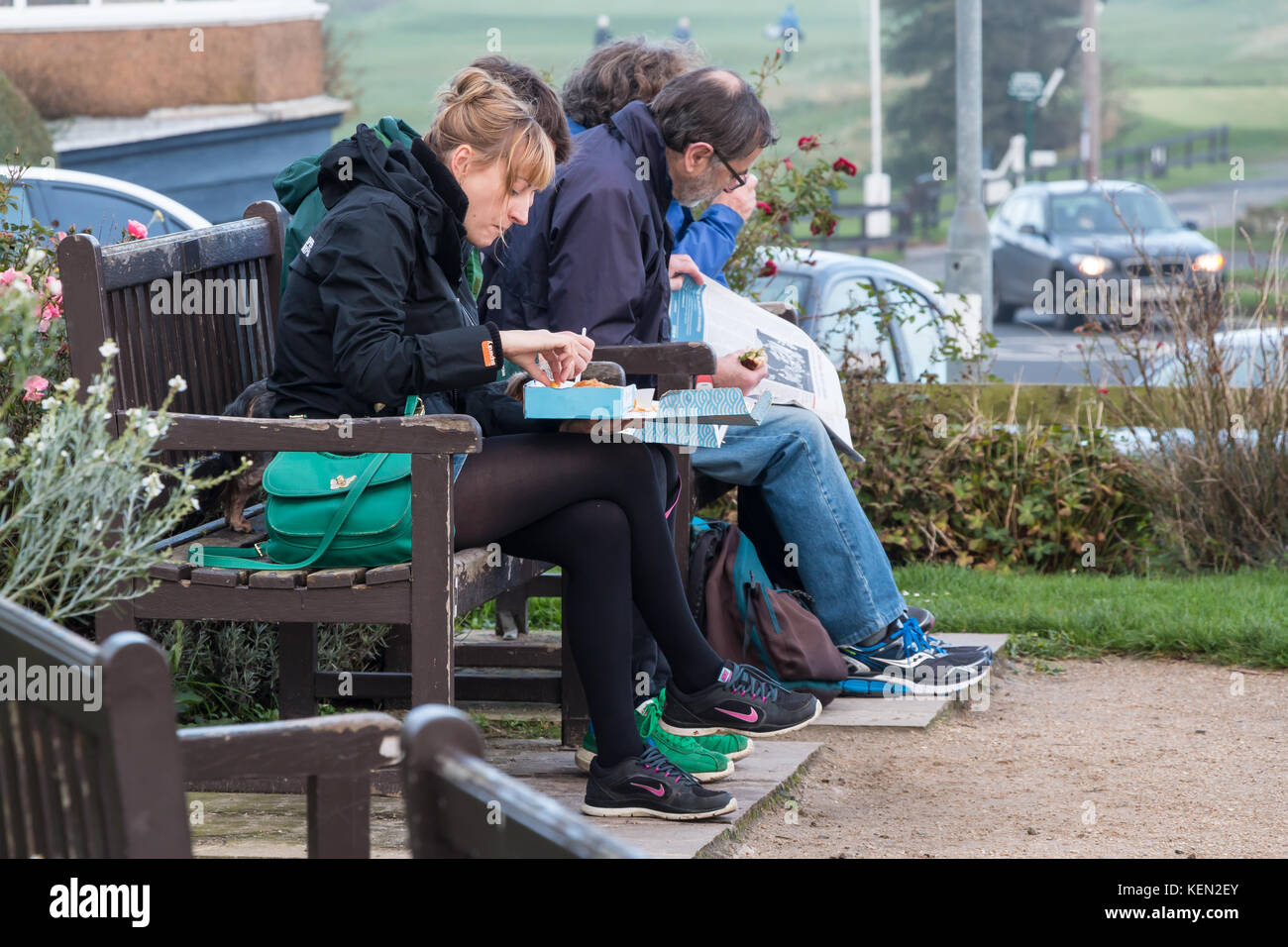 People eating traditional English fish and chips at an outdoor seating area at Alnmouth, Northumberland, UK Stock Photo