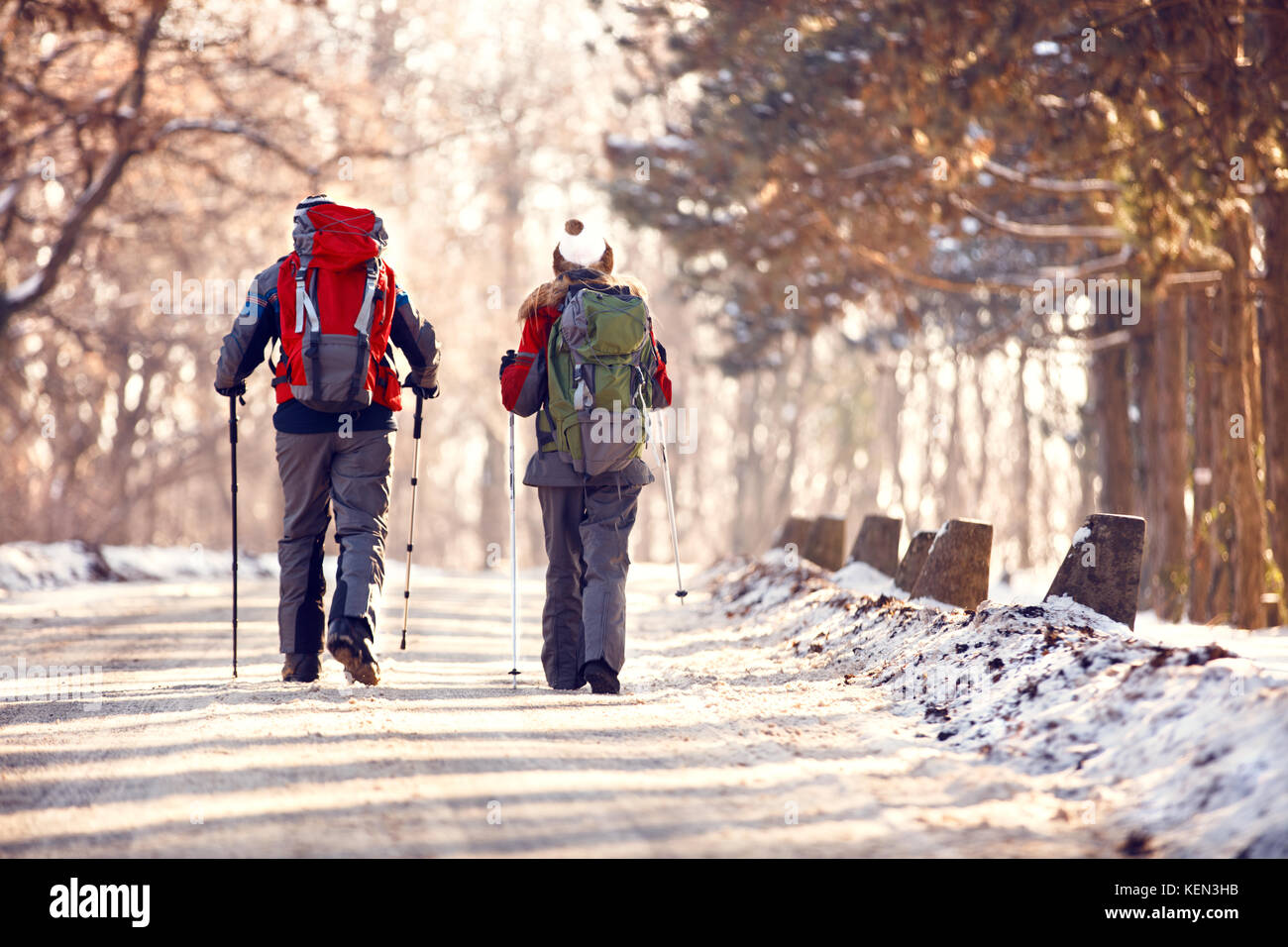 Male and female hikers hiking in winter, back view Stock Photo - Alamy