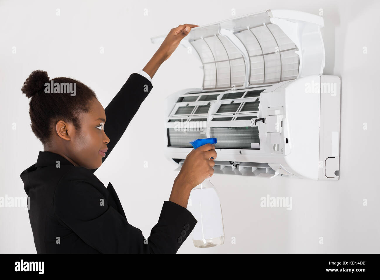 Young African Businesswoman Cleaning Air Conditioner In Office Stock Photo