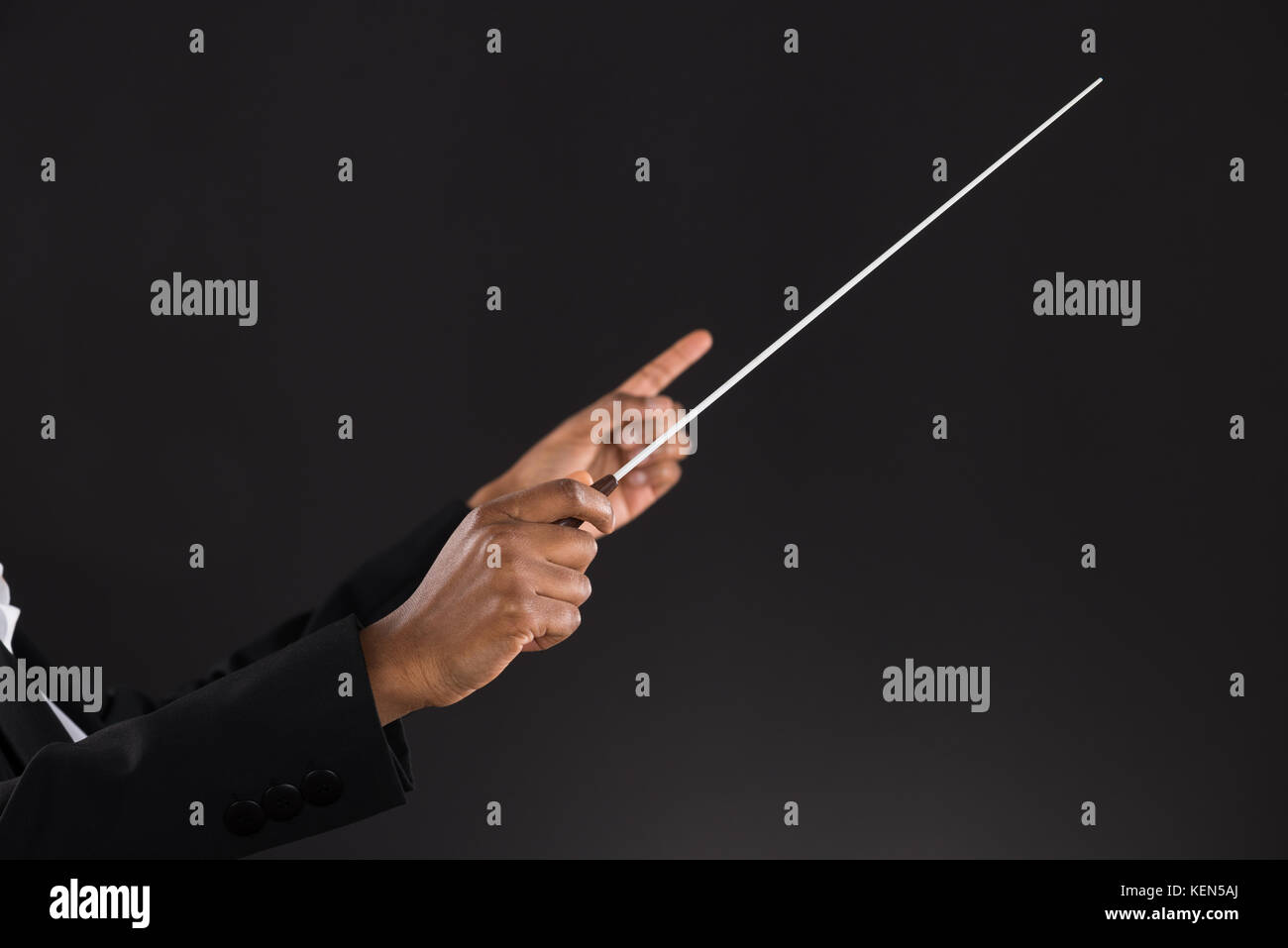 Closeup Of Female Orchestra Conductor Holding Baton Over Black