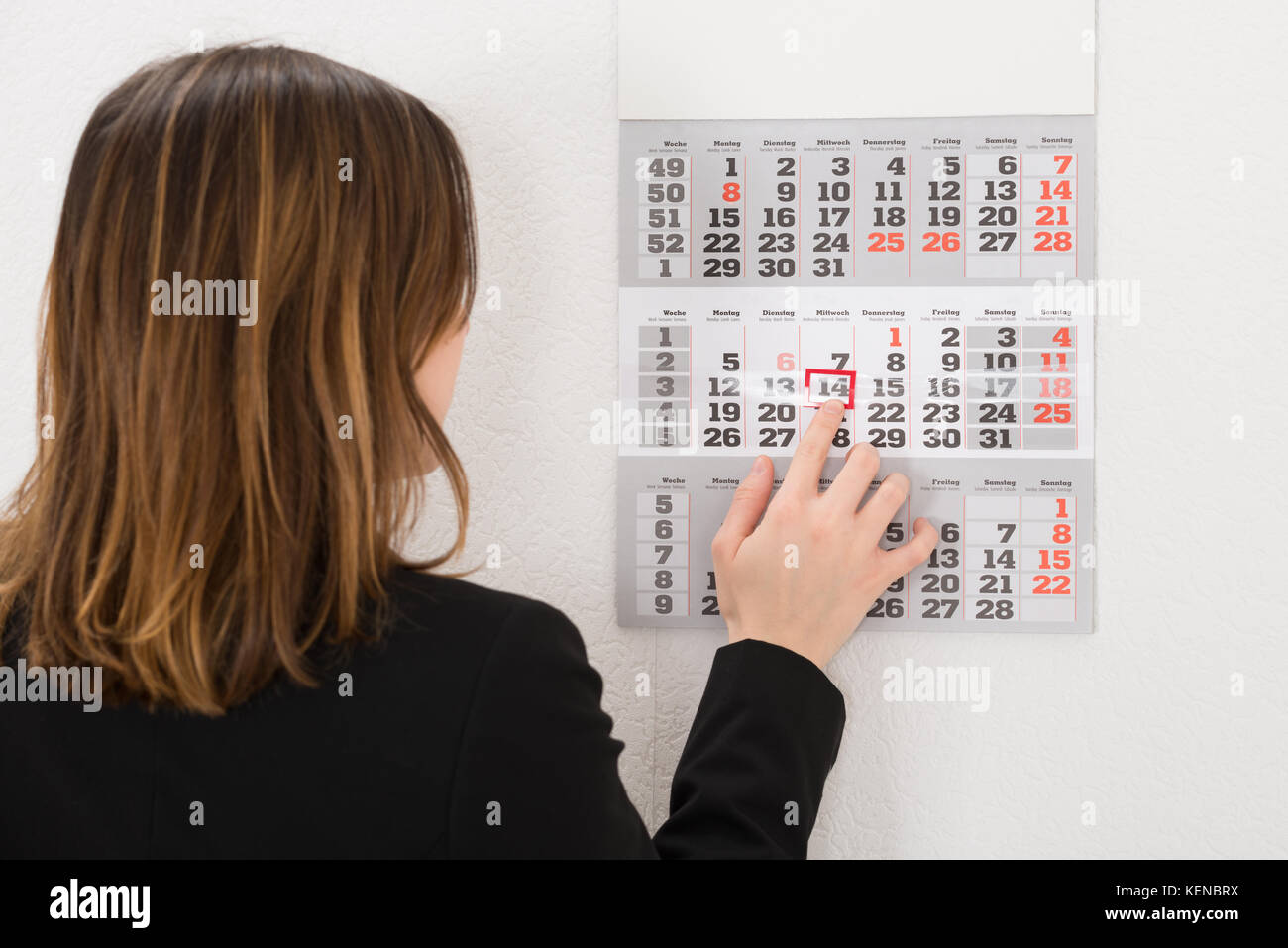 Close-up Of Young Businesswoman Placing Red Mark On Calendar Date Stock Photo
