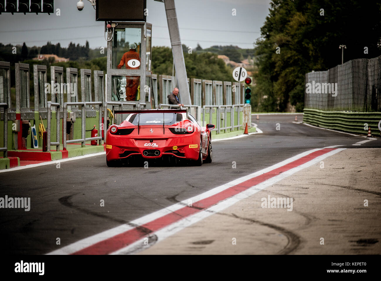 Racing motorsport red Ferrari waiting in pit lane for enter on circuit track rear view Stock Photo